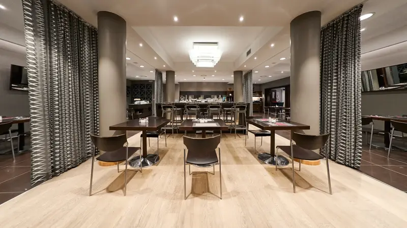 La sala del ristorante Eagle: tavoli apparecchiati in fila fra le tende a disegno bianco e nero