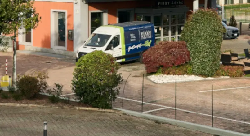 Il piazzale davanti all’ingresso dell’hotel: la navetta ferma davanti alla porta e i posti segnati a terra